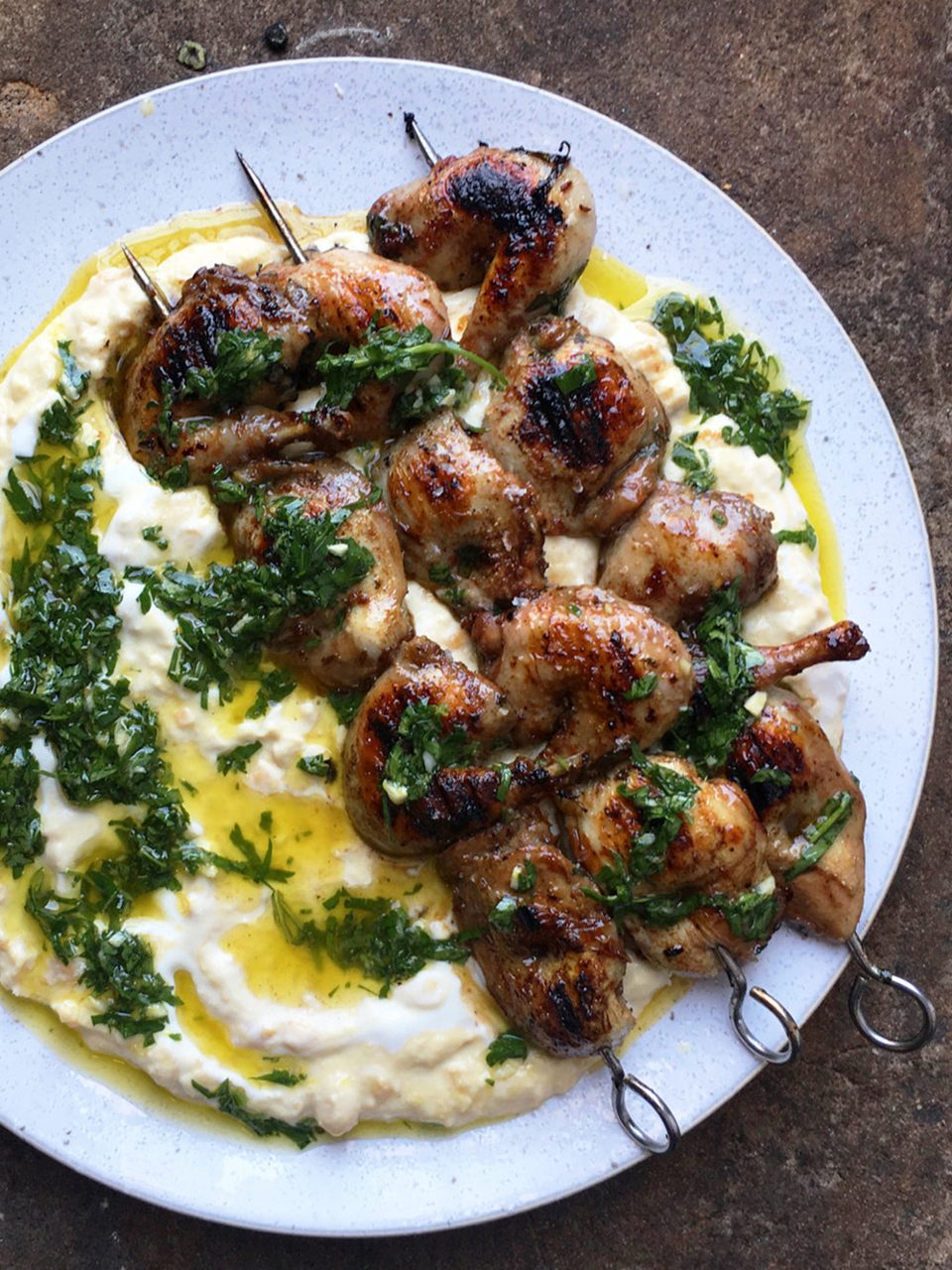 Hummus con codorniz a la parrilla, jarabe de granada y salsa de perejil