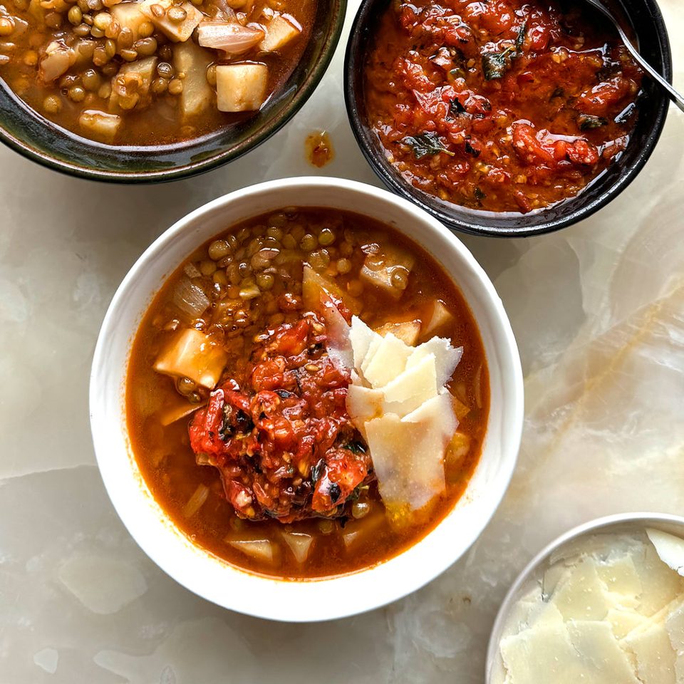 Sopa “stoup” de lentejas, hinojo y parmesano con salsa de tomate asado